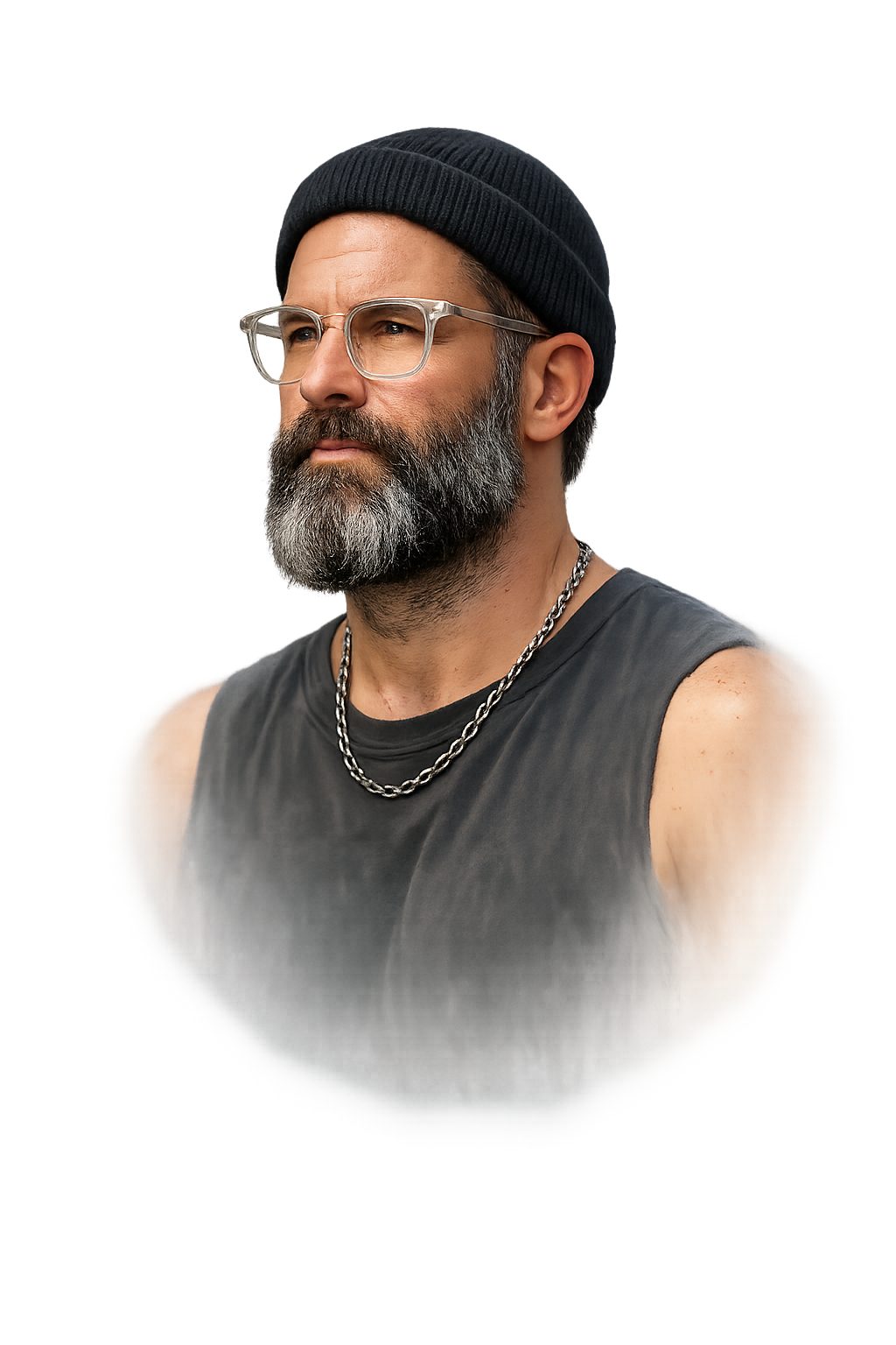 Portrait of Greygray, beanie, clear-frame glasses, beard, chain necklace, against a smoky charcoal and brass-gold background.